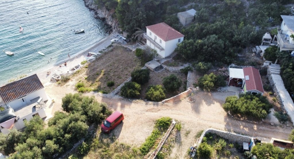 Pogled iz zraka na miren zaliv Skozanje na otoku Hvar z robinzoskima hišicama na plaži