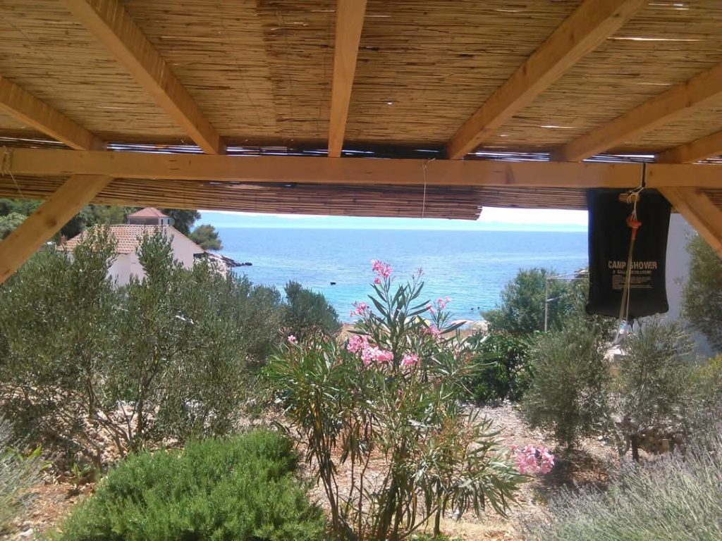 Pokrita terasa z rožami in pogledom na morje v hišici Skozanje