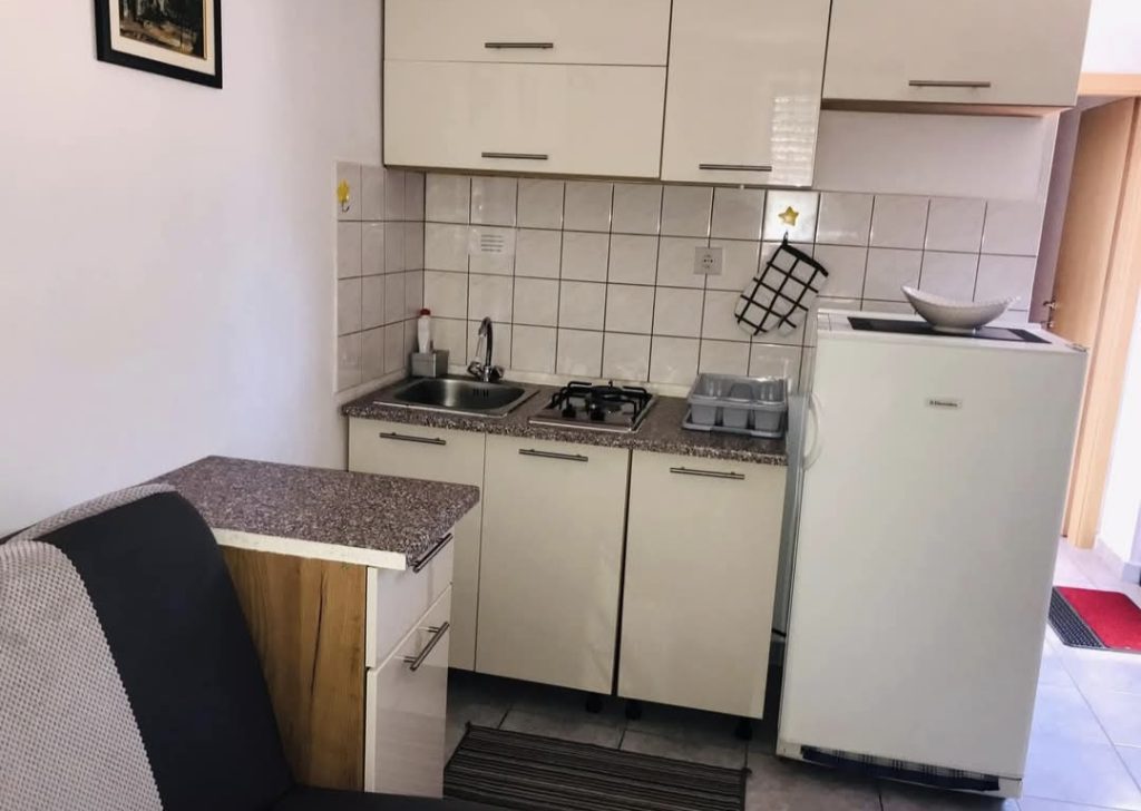 Majhna kuhinja z jedilnico in osnovno opremo za kuhanje v hišici Skozanje